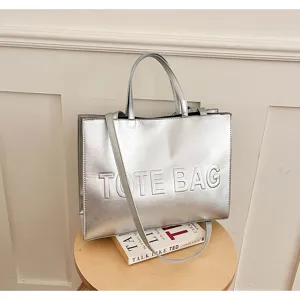 Detalle de bolso tote metálico plateado, bolso de hombro gran capacidad, elegante.