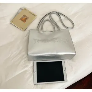 Detalle de bolso tote de cuero plateado, gran capacidad, bolso de hombro elegante y practico.