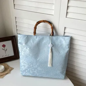 Elegante hellblaue Jacquard Handtasche mit Bambusgriff und weisser Quaste fuer Damen.