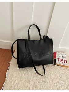 Vista detallada del bolso tote grande de cuero PU negro con correa en escena cotidiana.