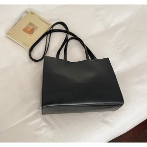 Vista detallada del elegante bolso negro, con costuras limpias y gran capacidad de almacenamiento.