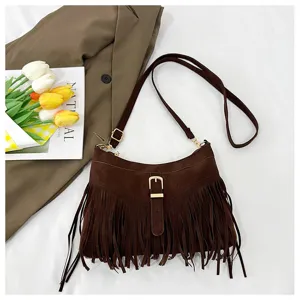 Detailed view of brown suede fringe shoulder bag featuring metal buckle and strap.
