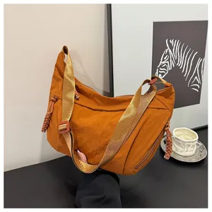 Vista dettagliata di una elegante borsa a tracolla in nylon caramello con ampia tracolla.