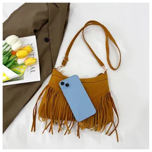 Detailed view of brown suede fringe crossbody bag with metallic hardware and adjustable strap.