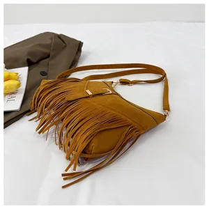 Brown suede fringe crossbody bag detail view, retro shoulder bag with metal buckle.