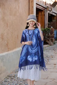Λεπτομερής άποψη της μπλε ethnic κάπας, με μαλακό ύφασμα και κομψά κρόσια στο κάτω μέρος.