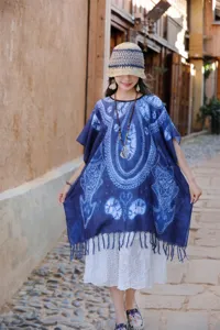 Λεπτομερής λήψη εθνοτικής μπλε tie-dye κάπας πόντσο με κομψό στρίφωμα με κρόσσια.