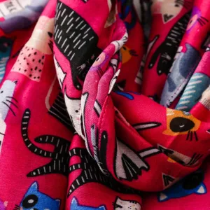 Detailaufnahme des Schals mit süßem Katzenmuster, kräftiges Rosa, weiche Textur.