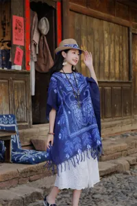 Λεπτομέρειες της κομψής μπλε ethnic tie-dye κάπας με κρόσσια και μοναδικό σχέδιο.