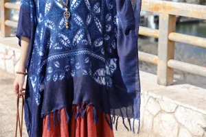 Λεπτομερής κοντινή λήψη που δείχνει το μπλε σχέδιο και τα κρόσσια της εθνοτικής κάπας.