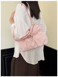 Dettaglio della borsa a spalla rosa a pois con tracolla regolabile per uso quotidiano.