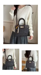 Vista detallada del bolso de mano retro con relieve para mujer con asa y cierre giratorio.