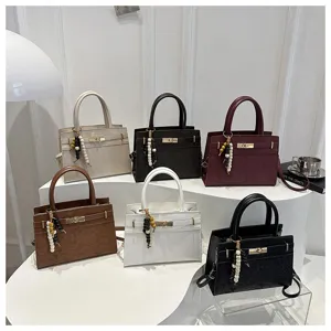Vista detallada de varios bolsos vintage con asa, cierre metálico y colgante de cuentas.