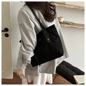 Detailed lifestyle view of a chic black leopard print shoulder tote bag in minimalist room.