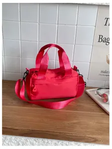 Bolso bandolera cilíndrico informal de nylon para mujer, bolso de mano rosa multifuncional.
