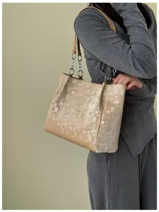 Detailed view of beige shoulder tote bag with unique numerical prints and chains.