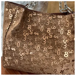 Stylish large capacity shoulder tote bag with metallic number print detail for daily commuting.