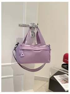 Vista detallada del bolso de barril de nylon morado para mujer, bolso cruzado y de hombro casual.