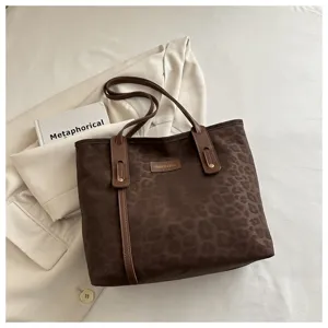 Detail view of the retro leopard print tote bag highlighting brown leather handle and fine texture.