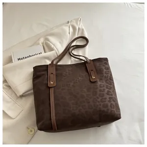 Brown leopard print tote bag detail showing premium leather strap and stitching texture.