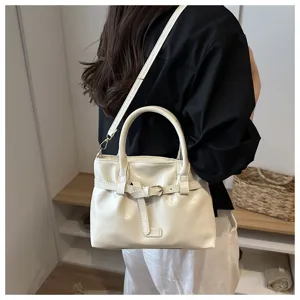 Detailed presentation of a stylish white oil leather handbag with chic belt buckle and shoulder strap.