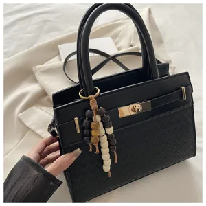 Elegante zwarte damestas schoudertas met chique draaisluiting en retro kralenhangers.