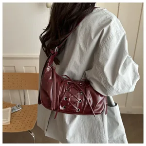 Sac porté épaule bordeaux plissé chic avec détail de laçage, sac baguette tendance sous les bras.