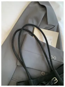 Λεπτομερής εικόνα της μαύρης σουέτ τσάντας tote με εξαιρετική υφή και μινιμαλιστικό σχεδιασμό.