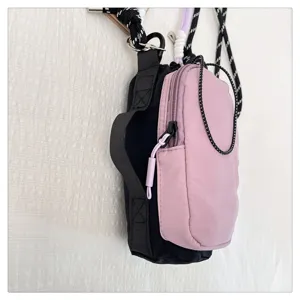 Nahaufnahme der kleinen pink-schwarzen Outdoor Umhaengetasche fuer Smartphone mit Gurten.