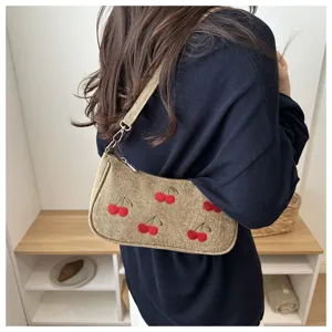 Detailed view of vintage khaki denim shoulder bag featuring cute embroidered red cherry patterns.