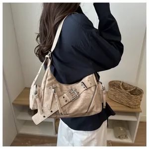Dettaglio borsa a tracolla moto vintage con fibbie in metallo e finitura beige rétro.