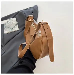 Primo piano della borsa a tracolla vintage marrone che mostra consistenza morbida e zip.