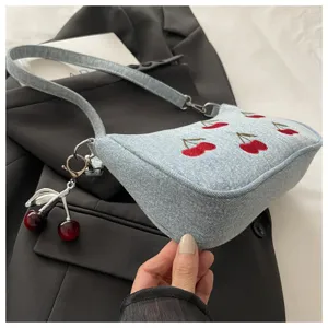 Chic denim shoulder bag with cute red cherry embroidery and metal pendant, perfect for daily wear.