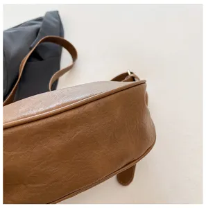 Vista dettagliata della elegante borsa a tracolla in pelle PU marrone con consistenza.