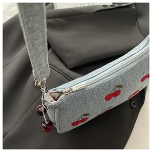 Vintage denim shoulder bag featuring cute embroidered cherries and shiny cherry pendants.