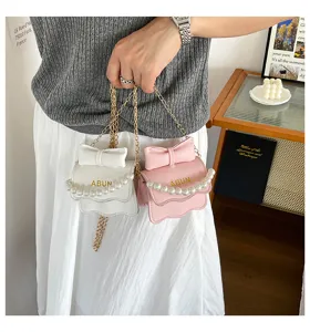 Détail de sac à bandoulière mini chic avec nœud et chaîne en perles pour la mode d'été.