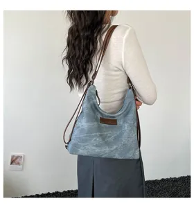 Vista di dettaglio lifestyle di una borsa tote zaino in tela lavata retrò con manici.
