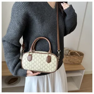 Stilvoller Detailblick auf die modische Zylinder Umhängetasche mit Monogramm und Leder.