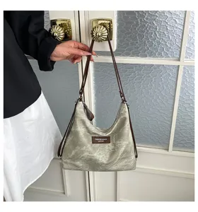 Primo piano dettagliato della borsa a spalla retrò con spallacci marroni e texture fine.