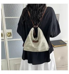 Dettaglio della borsa tote in tela dal design retrò con cinturini in pelle marrone e grande capacità.