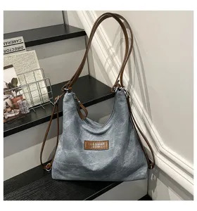 Vista dettagliata dello zaino e della borsa shopper retrò in tela con cinturini in pelle.