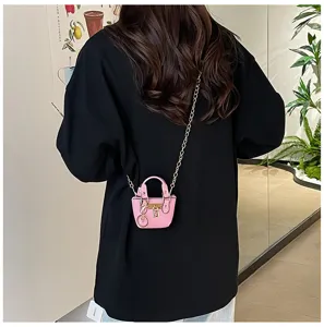 Vista detallada del bonito bolso cruzado rosa con correa de cadena metálica y un candado.