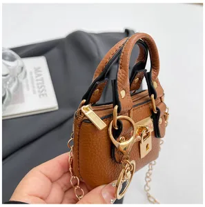 Mini bolso cruzado de cuero marrón con elegantes herrajes dorados y cadena.