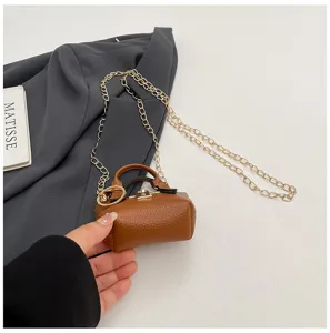 Detalle de mini bolso cruzado marrón con textura de piel, cierre metálico y cadena dorada.