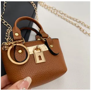 Bolso bandolera pequeño de cuero marrón con cadena dorada y candado elegante de mujer.
