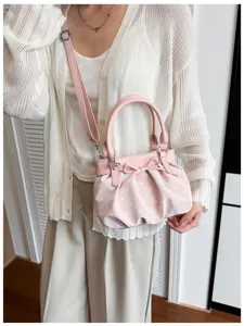 Detailed shot of pink pleated polka dot crossbody bag with cute bow, perfect for daily wear.