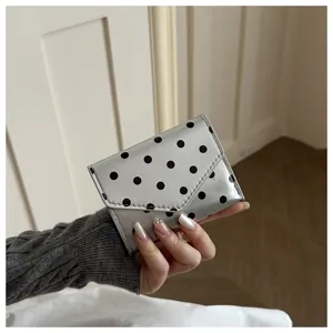 Polka dot detail view of the silver wallet, showing the stylish pattern and compact fold design.