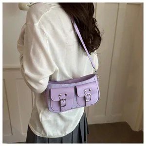 Nahaufnahme einer hellvioletten Umhängetasche mit zwei Vordertaschen und Schnallen.