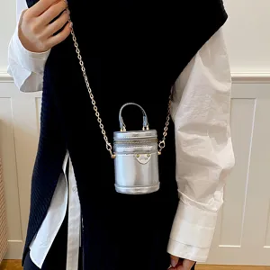 Mini sac bandouliere cylindrique argente metallique avec chaine chic et fermeture eclair.