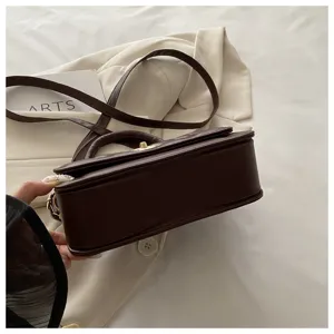 Nahaufnahme der dunkelbraunen gesteppten Ledertasche mit Tragegriff und Umhängegurt.